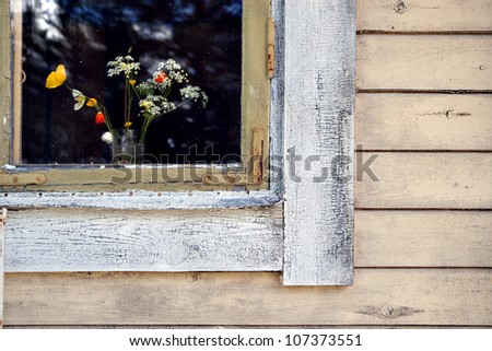 Part of window with flower vase on weathered wooden wall