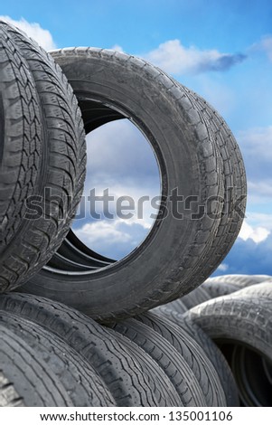 heap of tires on blue cloudy sky