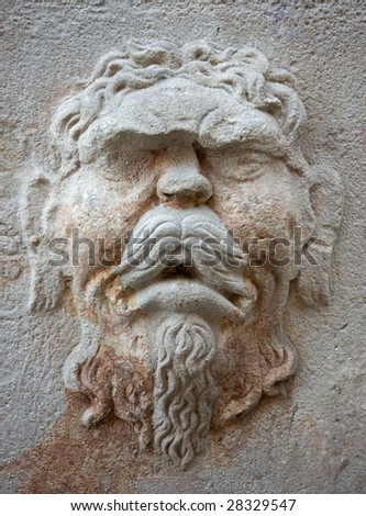 The face of an old man on an exterior stone wall in downtown Barcelona, Spain
