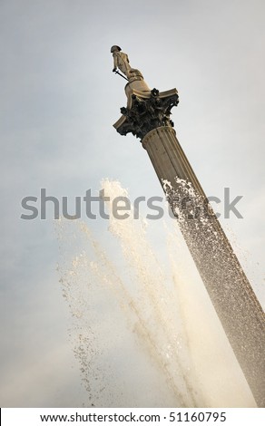 Low angle view of the Lord Nelson column at Trafalgar Square, London, with the cascade of a fountain in the foreground