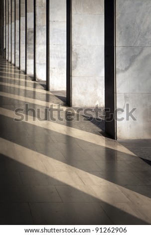 Columns with sunlight in the gaps and reflected in shiny floor