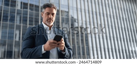 Foto Bild Ernster Mann, der auf einer Bank im Park auf sein Smartphone schaut