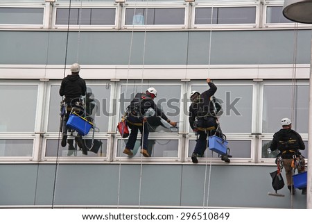 VIENNA, AUSTRIA - MAY 26TH, 2015:Window cleaners works on high rise building.Window cleaning is considered one of the most dangerous job in the world.