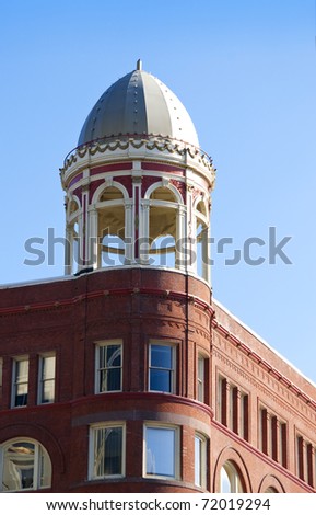 Small, round ornate tower atop a city building.
