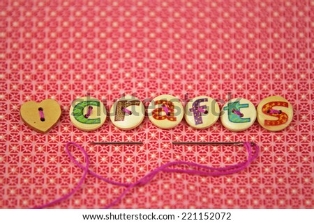 the word crafts spelled in hand painted letters on buttons on a vibrant textile background.