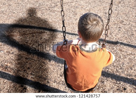 A young boy is sitting on a swing set and looking at a shadow figure of a man or bully at a playground. Use it for a kidnap, defense or safety concept. Foto d'archivio © 