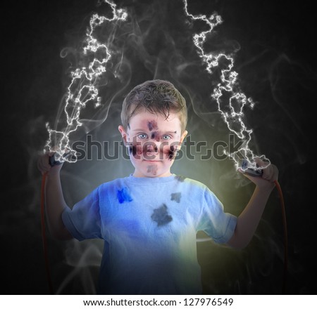 A young boy is holding two cord plugs with smoke and lightening coming out for an electricity power concept.