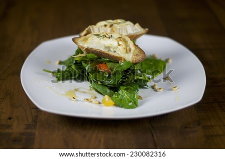 Toast with goat cheese on spinach salad