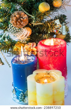 Three candles on the Christmas tree background