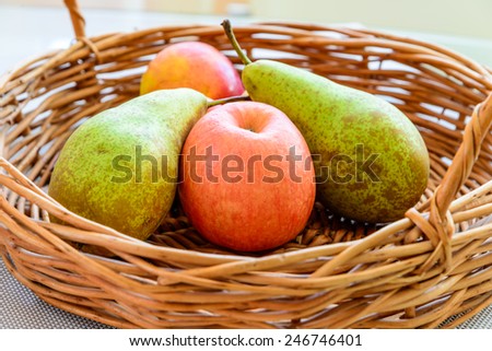 Still life composed of fruits and apples placed in a wicker baskets, lit by natural light