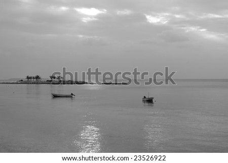 Idyllic sea scene with boat and island in black and white