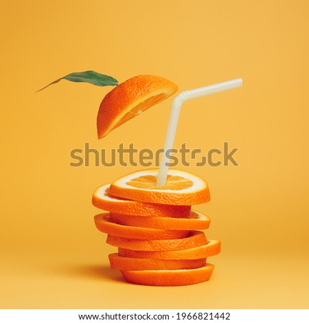 Summer composition with fresh stacked orange slices and straw on vibrant orange background. Creative healthy diet concept. Organic tropical fruit juice.