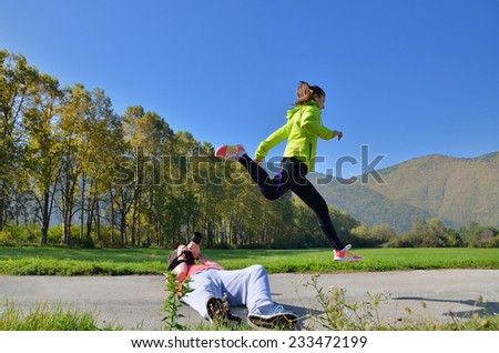 Fitness, sport, friendship and lifestyle concept - smiling couple with earphones running outdoors
