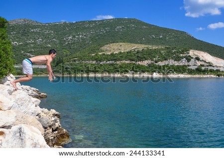 young man jumps into the sea, a beautiful summer day