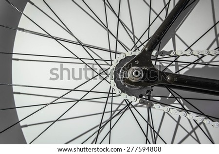 Part of fixed gear bicycle . Wheel part with chain and wire. Shadow of wire affect on background created abstract pattern