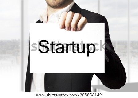 businessman in black suit  holding sign startup