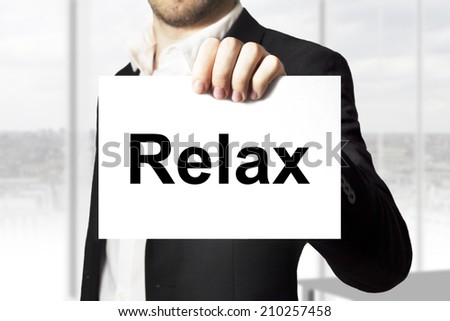 businessman in black suit holding sign relax