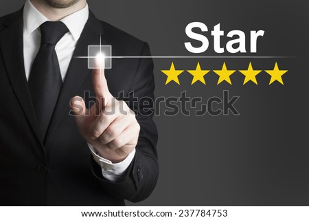 businessman in black suit pushing button star golden rating