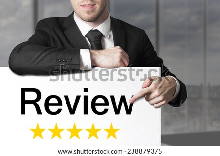 businessman in black suit pointing on sign review