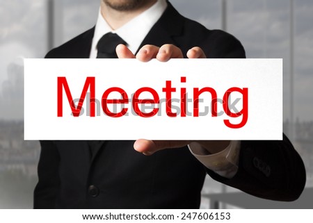 businessman in black suit holding sign meeting