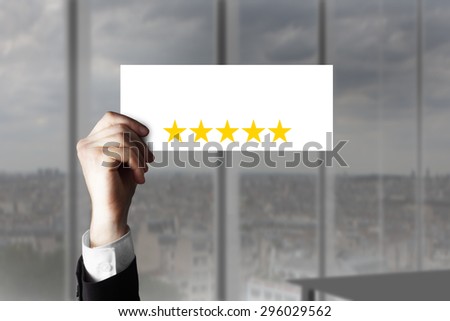 businessmans hand holding up small sign five rating stars