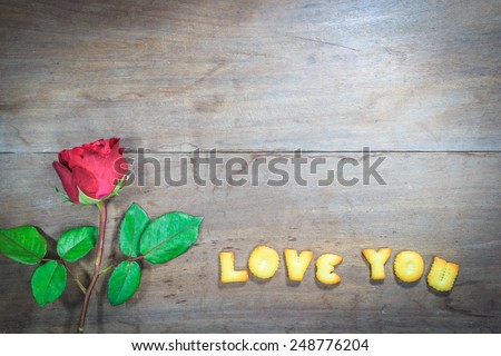 Happy Valentine's Day red roses on dark recycled wood background with word I Love You dessert