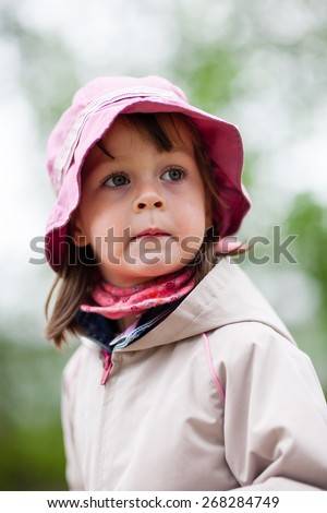 Portrait of cute little girl in nature. Side view, she is looking ahead at something or someone. Selective focus, shallow depth of field