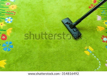 Vacuum cleaner cleans carpet, with copy space for text message, advertising - Spring Cleaning Concept