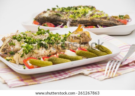 baked perch fish with cheese, potato ans onions served with boiled eggs, paprika and gherkins