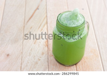 green tea smoothie on a wooden table