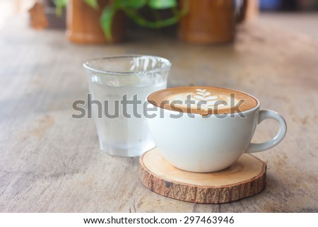 hot milk art coffee on wooden table , Vintage latte art coffee