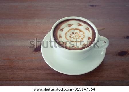 hot milk art coffee on wooden table , Vintage latte art coffee