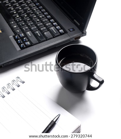 Black coffee on white office computer desk. White paper notebook is blank with pen on it/Black coffee on white computer desk