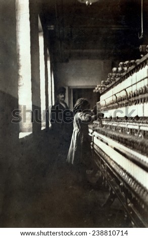 A textile mill. Little girl (48 inches high) work in Amoskeag Mfg. Co. She seemed to be 11 or 12 yrs. old. Manchester, N.H, photograph by Lewis Wickes Hine, May 25, 1909