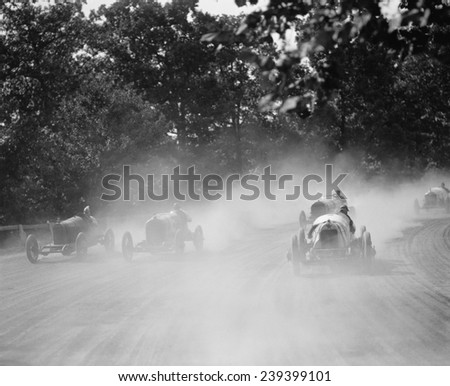 Five racing cars round the track bend in a cloud of dust at the Rockville, MD fair in 1923.