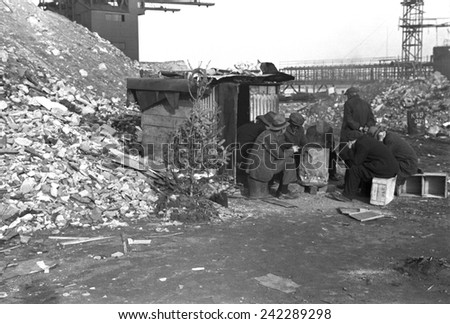 Hooverville at East 12th Street, New York City. Unemployed workers sit on crates by a shack with Christmas tree. January 1938 photo by Russell Lee.