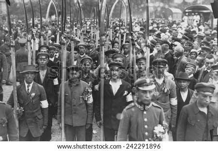 Polish army volunteers with scythes in a crowd of people in July 1920. The Russo-Polish War of 1919-20 followed the creation of the Polish Republic by the Versailles Peace Conference.