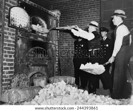 Federal Bureau of Narcotics agents shovel confiscated heroin blocks into incinerator in 1936.