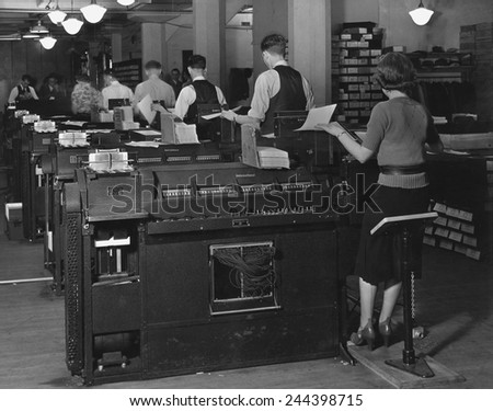 Social Security Administration clerks seated at massive tabulating machines, early computers used to manage individual records of millions of Americans in the Social Security system. Ca. 1940.