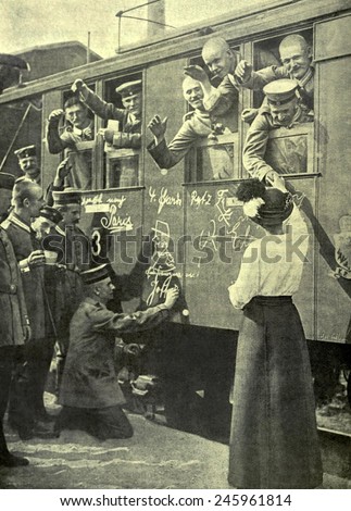 WWI. German soldiers on a train bound for the Western Front in the first days of the war. A spectator draws a caricature of French General Joffre on the side of the railway carriage. August 1914.