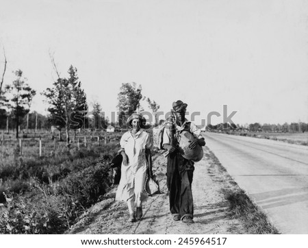 \'Oakies\' couple migrating. Cotton workers on the road carrying all they possess as they say \'Damned if we\'ll work for what they pay folks hereabouts.\' Crittenden County Arkansas May 1936.