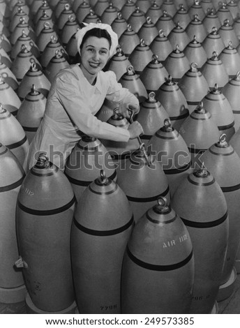 Canadian woman munitions worker tightening the nose plugs on 500-pound aerial bombs. 1942-43, during World War 2.
