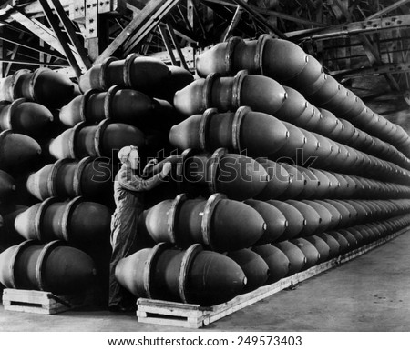 Woman war worker checks 1,000 lb. bomb cases loaded with explosives. Firestone Tire and Rubber Co., Omaha, Nebraska. May 1943 during World War 2.