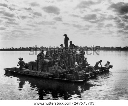 U.S. Army barge, powered by outboard motors, on the Irrawaddy River near Tigyiang, Burma. The soldiers were transporting a truck and ammunition during World War 2, Dec. 30, 1944.