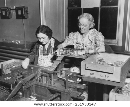 Mothers of the assembly line perform clip spring and bolt assembly at the Frankford Arsenal. Philadelphia, Ca. 1940-45. World War 2.
