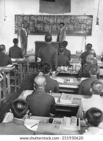 Japanese in Manchukuo create a new 100,000 police force in 60 days. Japanese instructors from Tokyo drill peasants in reading fingerprints. The instructor has an interpreter.