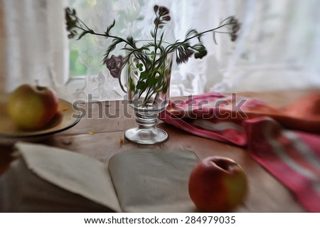 still life with a bunch of field flowers in the glass cup, apples, a book and a kitchen towel
