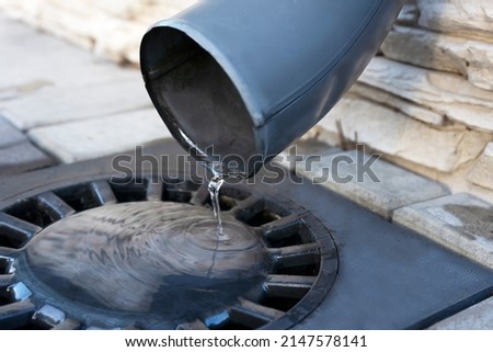 Water from melted snow flowing from plastic gutter into drainage system. ストックフォト © 
