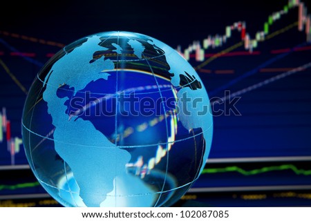 Glass globe over stock data on computer screen