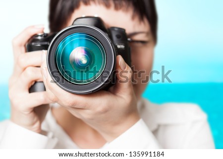 Pretty woman is a professional photographer with slr camera